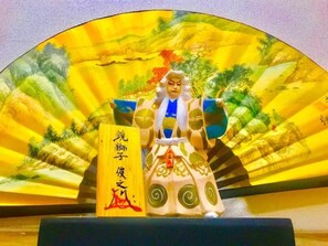 A traditional Chinese figure with a fan and a scroll. - Local Nakasu Apartment (Fukuoka)