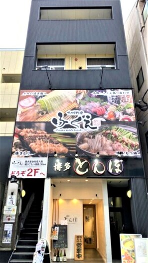 A restaurant with a large signboard displaying various dishes. - Local Nakasu Apartment (Fukuoka)