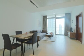 Un salon moderne comprenant une table à manger, des chaises, un canapé et un meuble pour la télévision.
