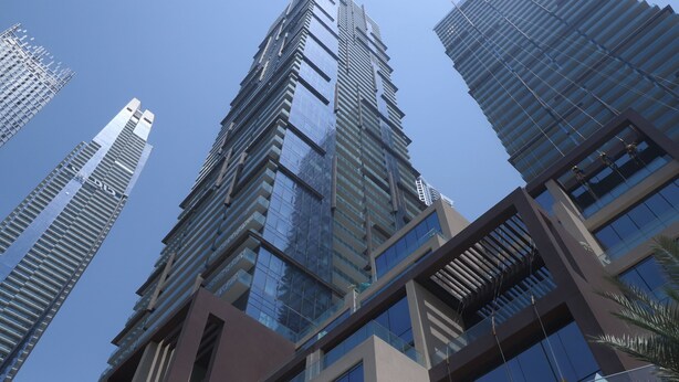 Un edificio moderno de gran altura con múltiples ventanales de vidrio.