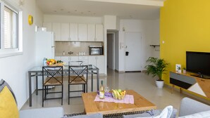 Un apartamento moderno con comedor, cocina, sala de estar y una pared de acento amarilla.