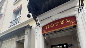 A hotel entrance with a tiled floor, a sign reading "HOTEL", and a door with a window above it. - Hôtel du MontLouis (Paris)