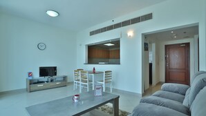 Un salon moderne comprenant un canapé, une table basse, un téléviseur et un coin repas avec des chaises et une table.