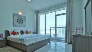 Une chambre d’hôtel moderne, dotée d’un grand lit, offrant une vue sur la ville et agrémentée d’une pancarte de bienvenue.