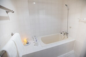 A modern bathroom with a bathtub, a shower, and a towel rack. - White House (Uruma)