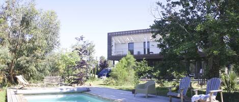 A pool area with lounge chairs and a deck.