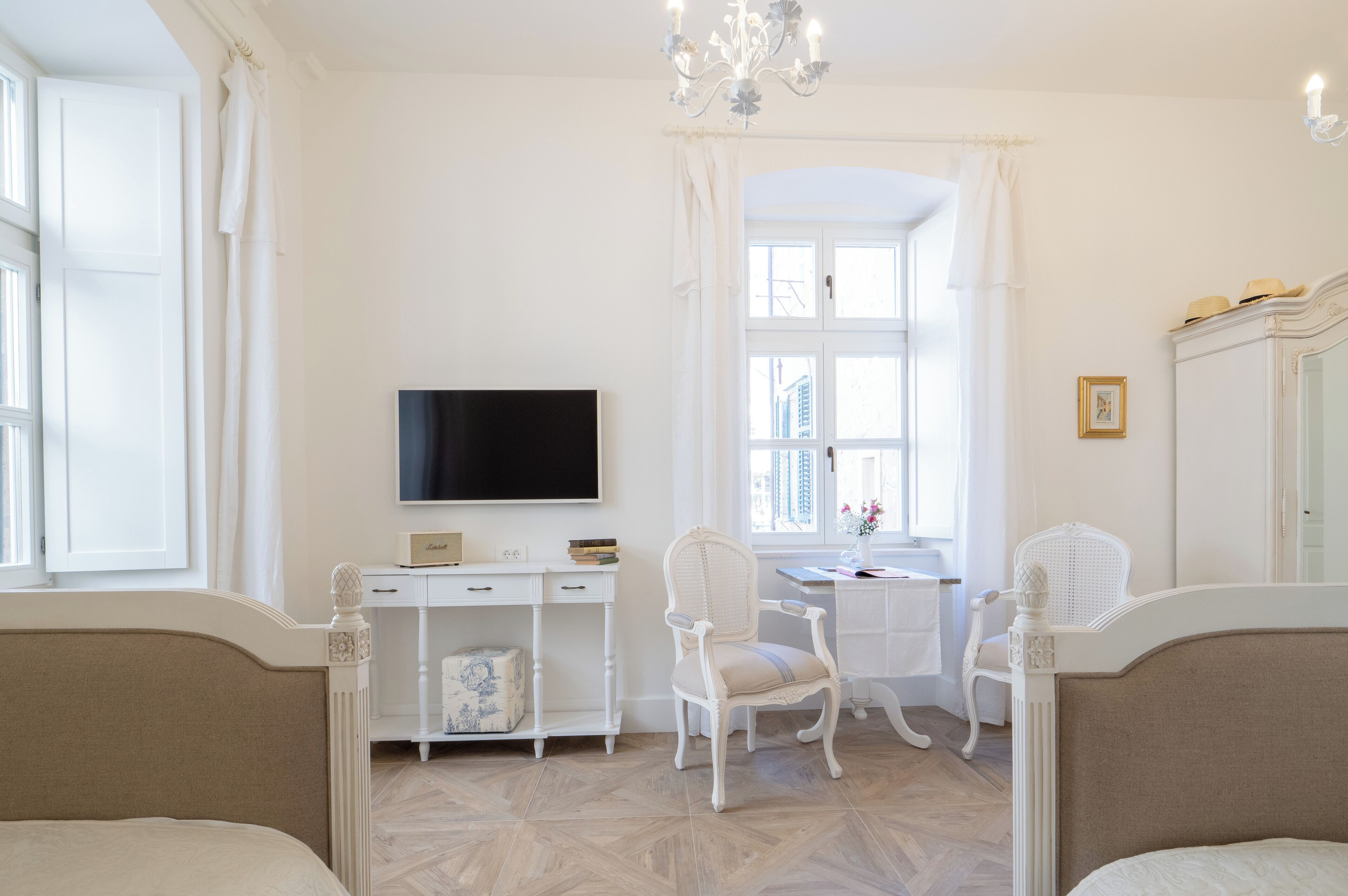 A room with a bed, a desk, a chair, a television, and a window.