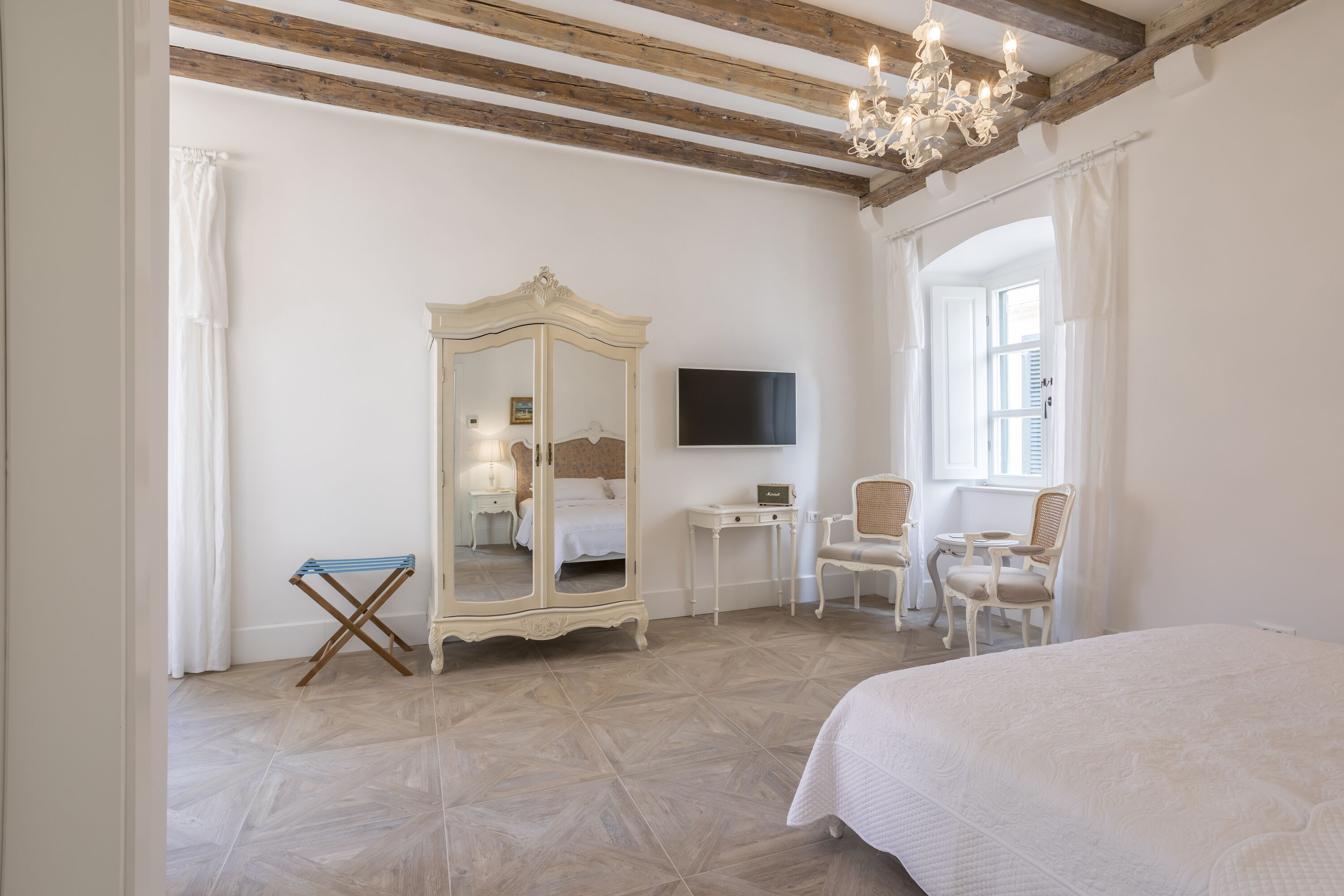 Un dormitorio con cama, armario, escritorio y televisor.