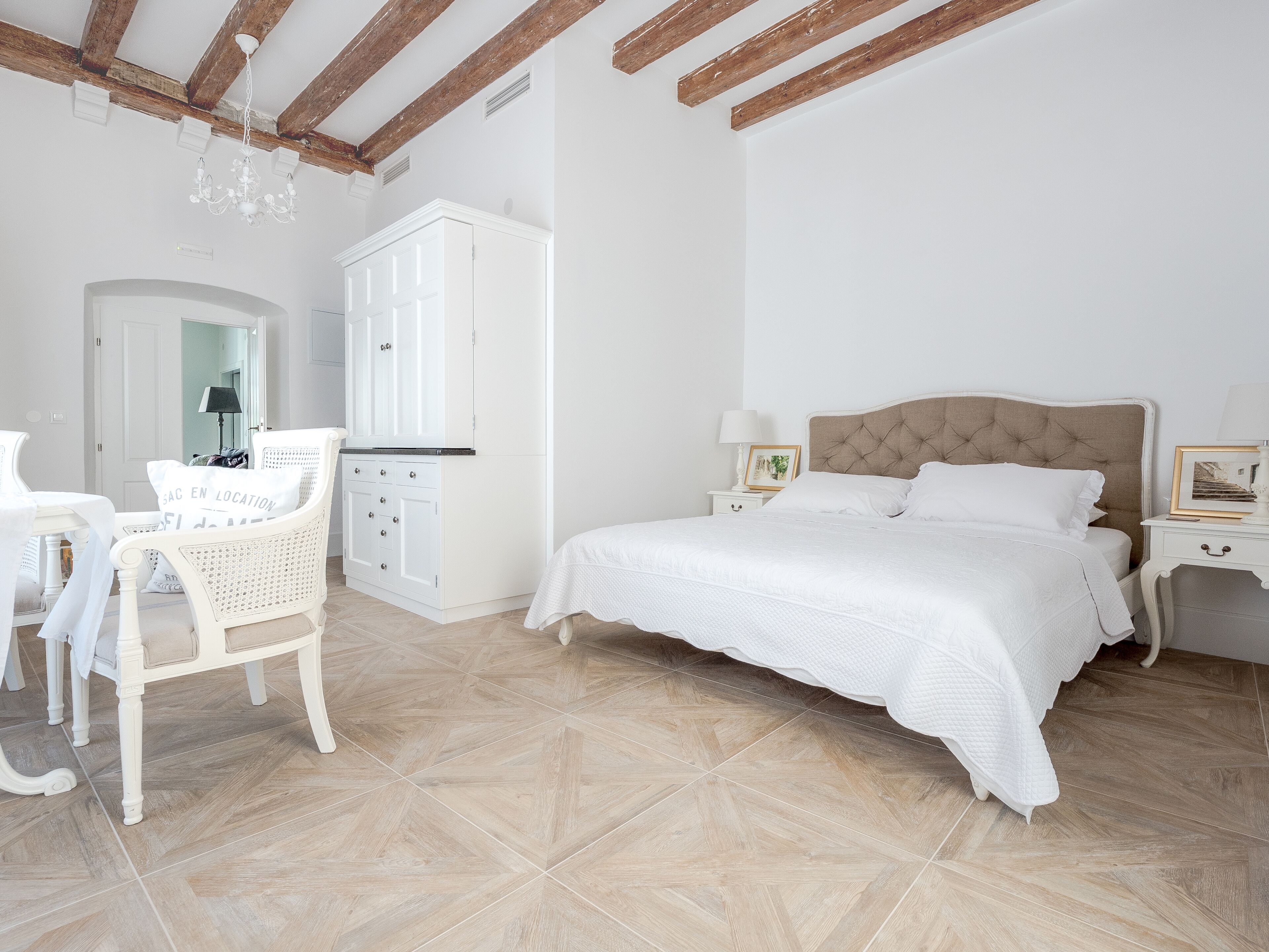 A bedroom with a bed, a chair, a wardrobe, and a desk.