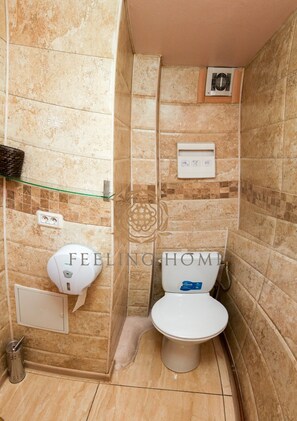 A bathroom with a shower, toilet, and a hand dryer. - Feeling Home Apartments (Bucharest)