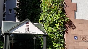 A hotel entrance with a sign reading "HOTEL ROBERT MAYER" and a number "44" on the wall. - Hotel Robert Mayer (Frankfurt)