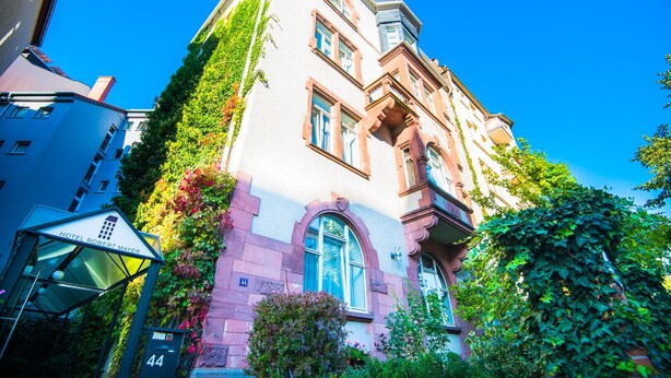 A historic building with a classic architectural style, featuring a prominent arched entrance and multiple windows. - Hotel Robert Mayer (Frankfurt)
