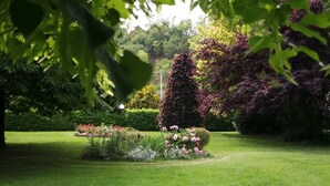 A well-maintained garden with a variety of plants and flowers, a neatly trimmed lawn, and a pathway leading through the greenery. - Affittacamere Marisa (Valeggio sul Mincio)