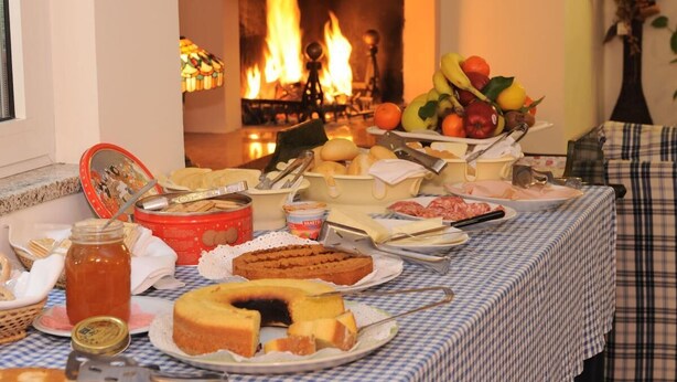 A buffet table with various food items and a fireplace in the background. - Affittacamere Marisa (Valeggio sul Mincio)