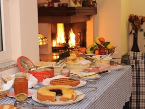 Una mesa de buffet con diversos alimentos y una chimenea al fondo.