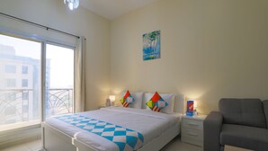 A bedroom with a bed, a nightstand, a lamp, a painting, and a view through a window.