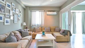A living room with two sofas, a coffee table, and a wall adorned with framed pictures. - Santo Domingo Modern Apartment (Santo Domingo)