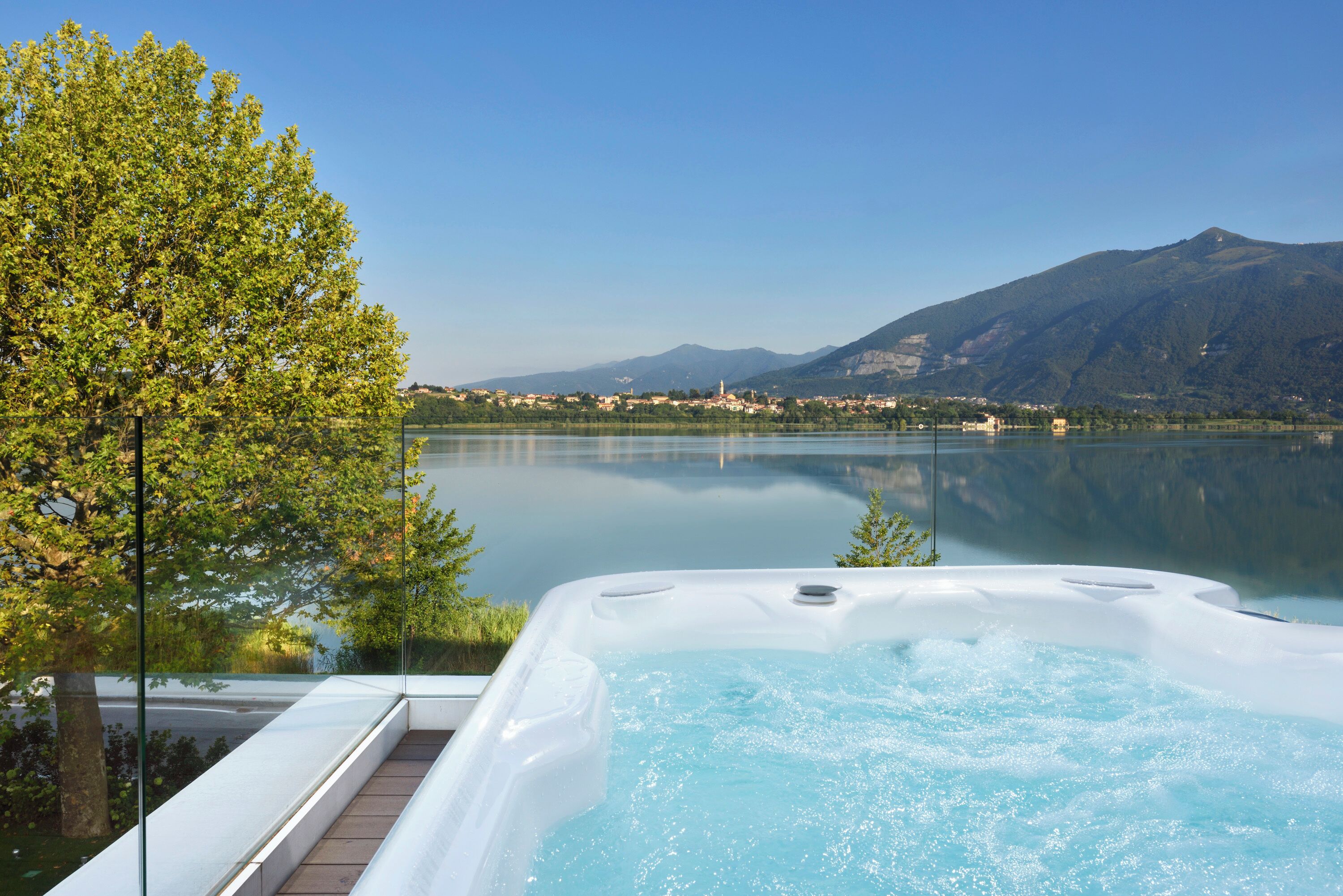 Een hottub met uitzicht op een helder meer en bergen op de achtergrond.
