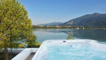 Een hottub met uitzicht op een helder meer en bergen op de achtergrond.