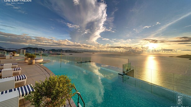 A luxurious infinity pool with a clear view of the ocean and city skyline at sunset. - The Empyrean Nha Trang (Nha Trang)