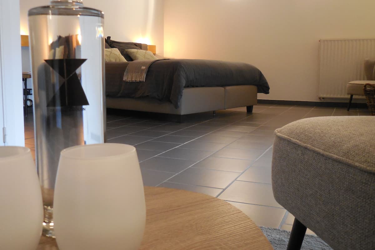 A modern bedroom with a bed, bedside lamps, and a nightstand.