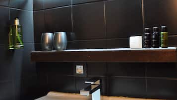 Een badkamer met een bad, een plank met toiletartikelen en een handdoek.