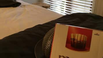 Une chambre d’hôtel avec un lit, une lampe de chevet et une fenêtre avec des stores.