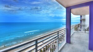 A balcony with a view of the ocean and beach.