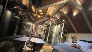 Een moderne badkamer met een ruime badkuip, een aparte douche en een wastafel met spiegel.