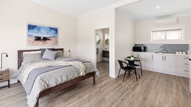 Une chambre à coucher avec un lit, une table de chevet et un tableau accroché au mur.