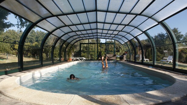 An indoor swimming pool with a glass ceiling and stone flooring. - Agriturismo Walden (Ficulle)