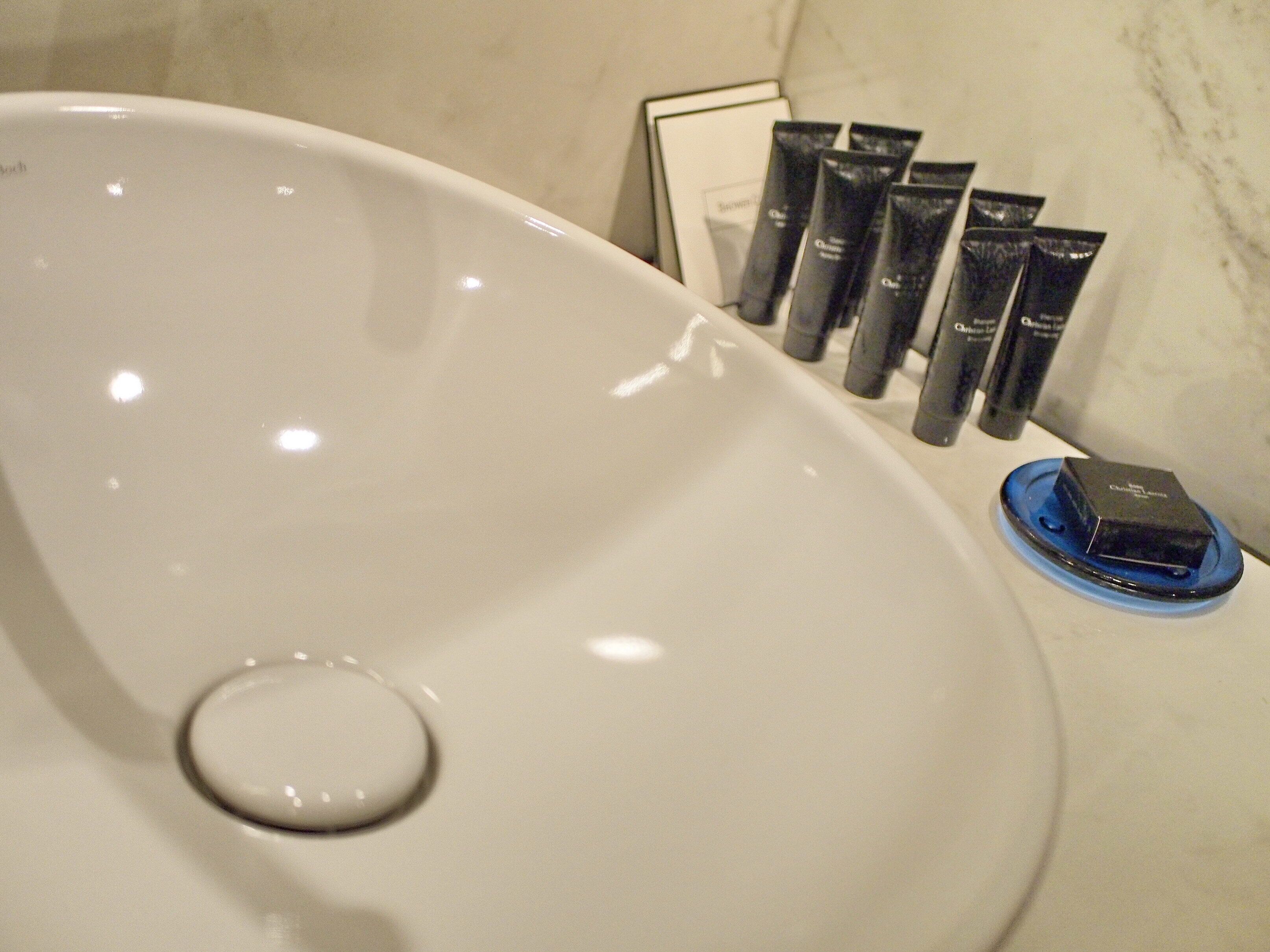 Een wastafel in een badkamer met toiletartikelen.