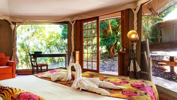 A tent-style room with a bed, a desk, and a lamp. - Gadiamb City- Glamping (Saint-Pierre)