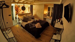 Un dormitorio con cama, mesita de noche y ventana con cortinas.