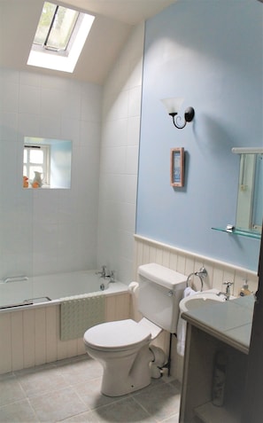 Een bad/douchecombinatie, een haardroger, handdoeken, zeep