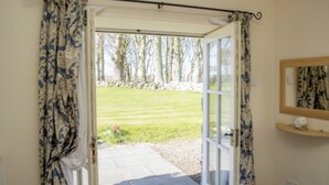 A room with a door leading to a garden. - 3 bedroom cottage, with far reaching views of the garden and open countryside. (Whitehills)