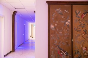 A hallway with a wooden door featuring floral and bird artwork. - Palazzo Pasta Malpensa (Gallarate)