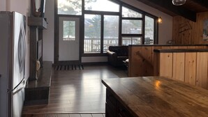 Eine geräumige Küche mit großen Fenstern, Holzboden und einer Holztheke.