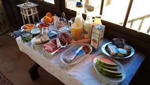 A breakfast table with various food items and drinks.