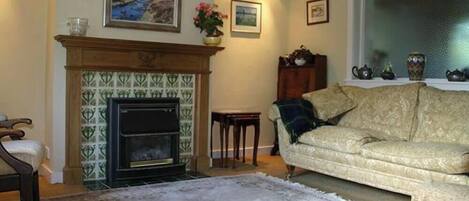 Una sala de estar con chimenea, un sofá y una alfombra.