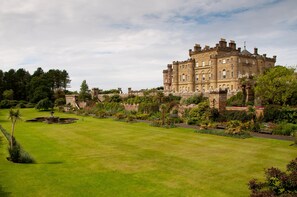 A large, historic building with a well-maintained lawn and garden.