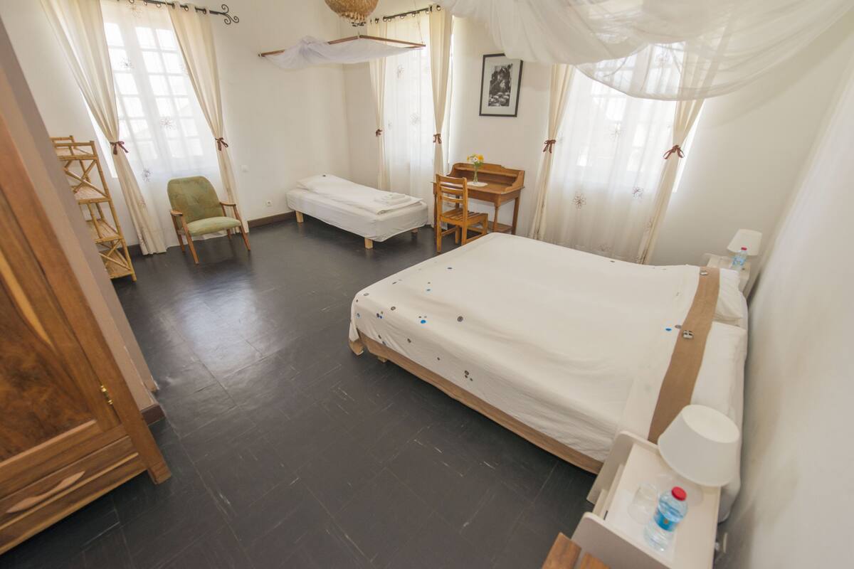 Ein Schlafzimmer mit einem großen Bett, einem Holztisch, einem Stuhl und einem kleinen Tisch.