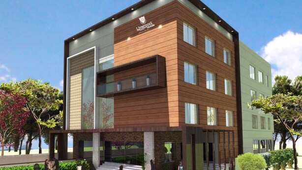 A modern building with a sign reading "Liverpool Hotel." It features a multi-story structure with a mix of wood and stone facades, large windows, and a central entrance. - Liverpool Hotels, Outer Ring Road, Marathahalli (Bengaluru)