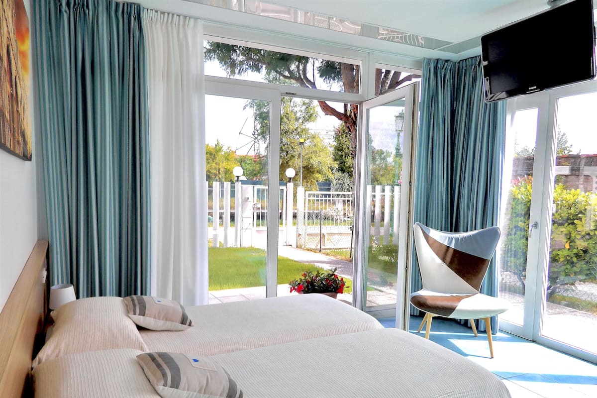 A bedroom with a large bed, a chair, and a TV.