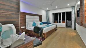 A hotel room with a bed, a desk with a chair, a window with curtains, and a ceiling fan. - Hotel Rock Villa Dalhousie (Dalhousie)