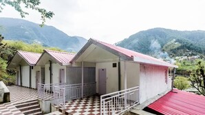 A building with a checkered floor, a red roof, and a view of mountains in the background. - Hotel Rock Villa Dalhousie (Dalhousie)