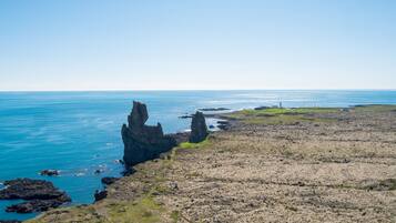 Un paysage côtier caractérisé par un terrain rocheux et la présence d’un phare.