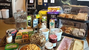 A table with food items, a wall with artwork, and a door.