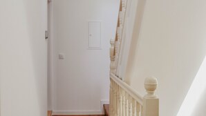 A narrow hallway with wooden flooring and white walls. - Spacious, light-filled one-bedroom apartment (self check-in) (Coimbra)