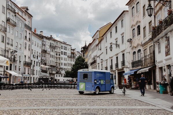 A street with buildings, a blue tram, and a person walking. - Spacious, light-filled one-bedroom apartment (self check-in) (Coimbra)